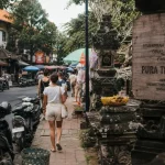 Jalan raya ubud bali : scooters et piétons près des offrandes balinaises