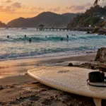 Lombok surf à Kuta Lombok, planche sur sable et surfeurs au loin